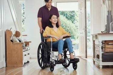 Ein Pfleger unterstützt nach einem Krankenhausaufenthalt